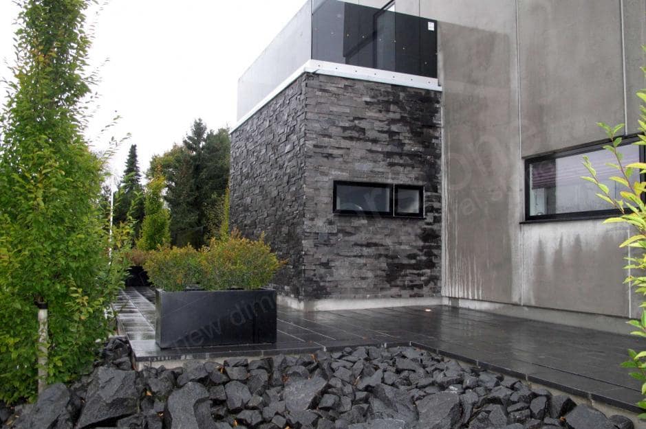 Norstone Charcoal XL Stone Veneer Panel used on the exterior of a residential home on a bump out with an open air terrace on the flat roof above it